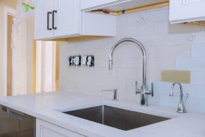 Surowe i przytulne wnętrze: spiek kwarcowy i płytki imitujące beton w aranżacji kuchni i łazienki
